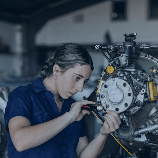 A female mechanic working on an engine