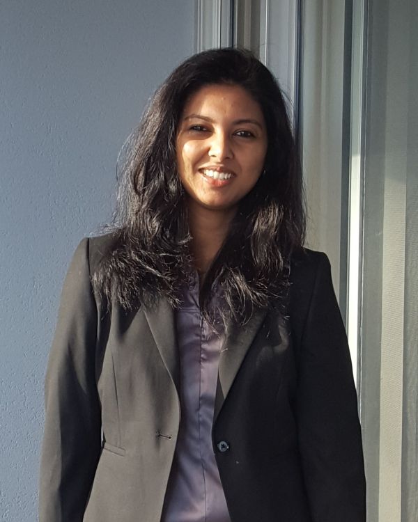 Ankita is wearing a black suit and is smiling at the camera. Ankita porte une chemise noire et sourit a la camera. 